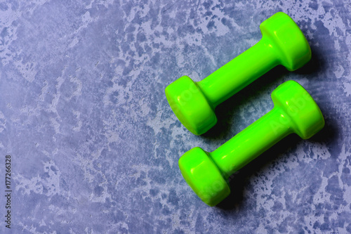 Barbells in light weight. Dumbbells made of bright green plastic