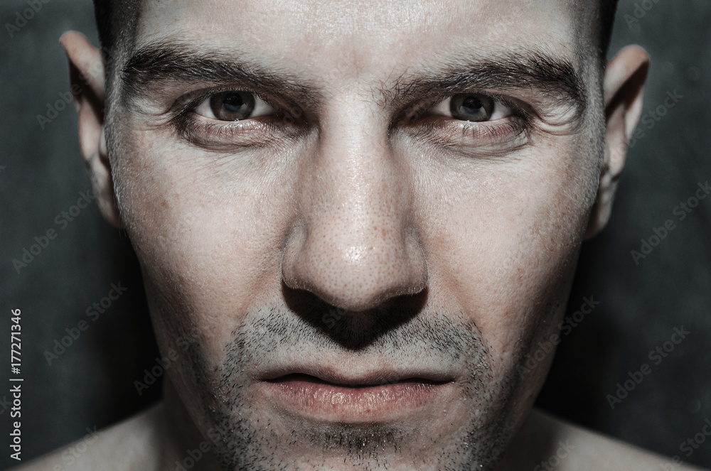 Obraz premium Portrait of a European male close-up with bristles on a gray background