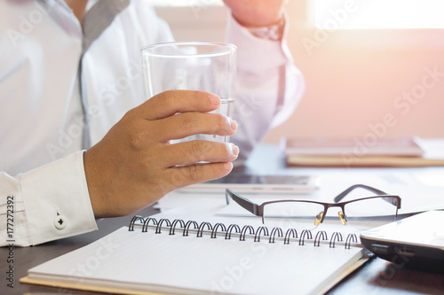 businessman holding glass of water and removing glasses on table  relax and healthy concept.