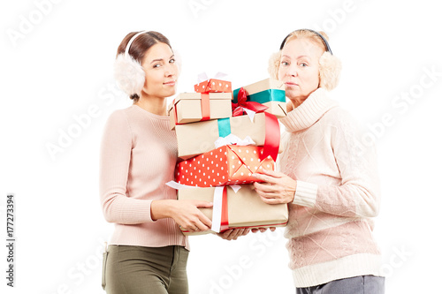 Portrait of senior mother and adult daughter exchanging Christmas gifts