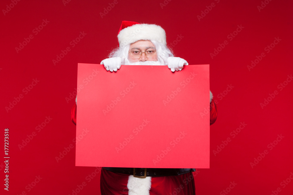 Santa Claus pointing in blank advertisement banner isolated on red background with copy space red leaf Santa Claus pointing in blank advertisement banner isolated on red background with copy space red leaf