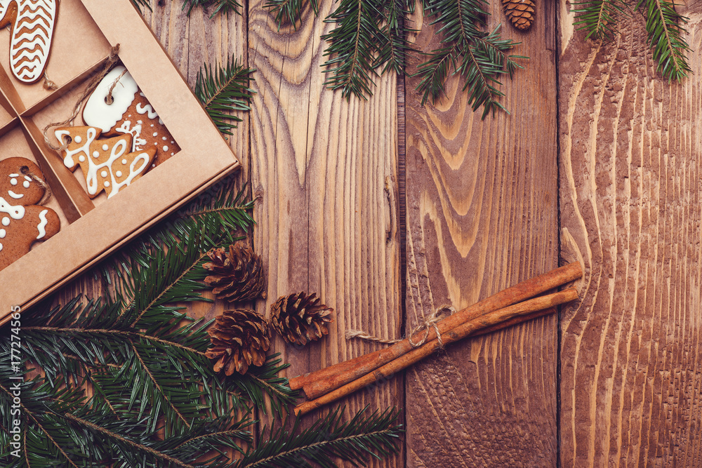 Obraz premium Christmas wooden background with fir tree and gingerbread.