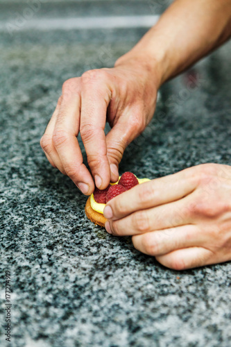 pâtissier prépare une tartelette framboise