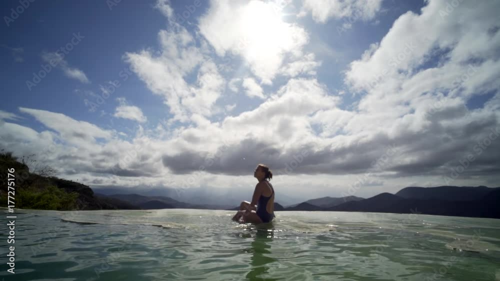 panoram with young girl siting in mineral pool,figure reflecting in water, Mexico Hierve el Agua panoram with young girl siting in mineral pool,figure reflecting in water, Mexico Hierve el Agua