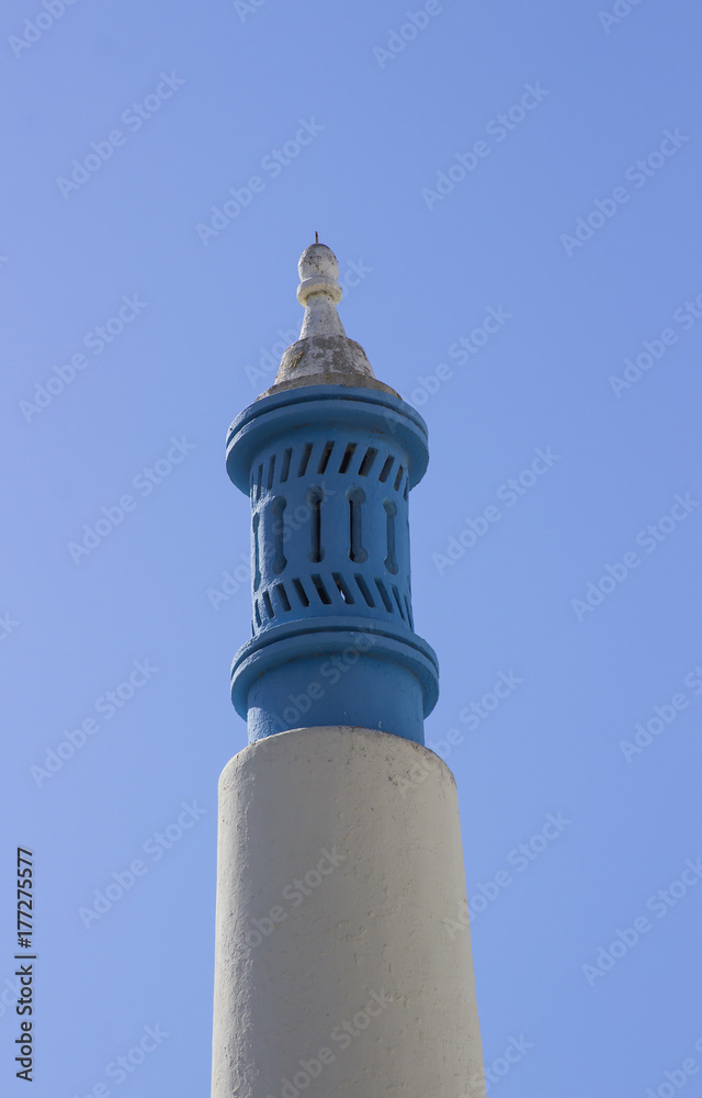 An ornamental blue clay chimney pot continental style on a cottage in the old town in Albuferia in Portugal