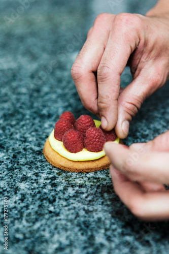 pâtissier prépare une tartelette framboise