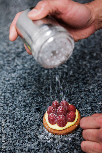 pâtissier prépare une tartelette framboise