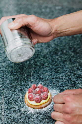 pâtissier prépare une tartelette framboise photo