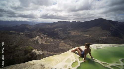  young women siting on the brink of mineral pool,crane shot open beautiful view, Mexico Hierve el Agua photo