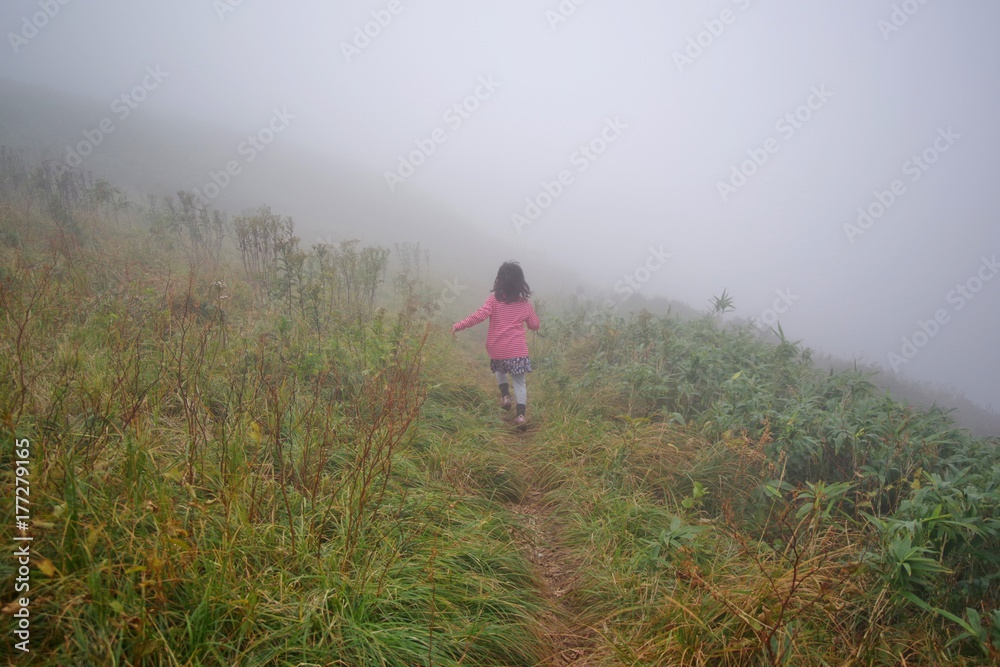 濃霧の山道を歩く女の子