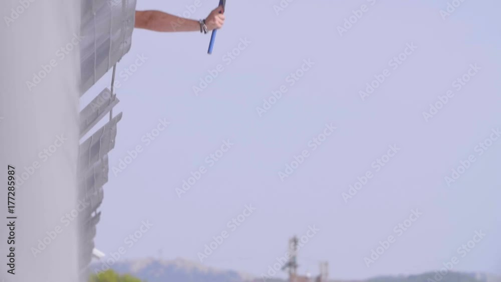 Man holding and waving Checkered race flag in slow motion at finish line on a raceway. Victory, achievement, success and sport concept.