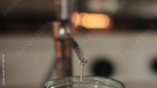Alcohol distillation equipment, hooch fluid flow into glass jar
