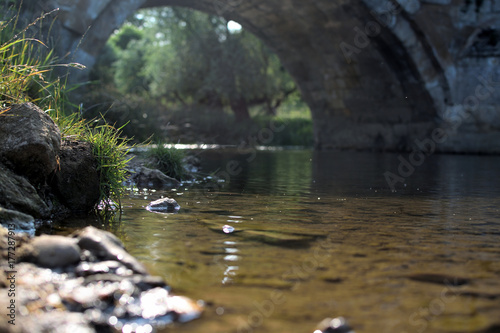 a low shot of a river going under a bridge