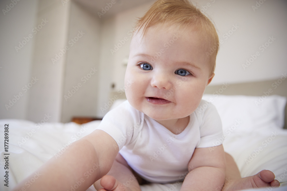 Happy Baby Boy Sitting On Parents Bed Happy Baby Boy Sitting On Parents Bed
