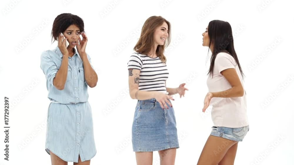 Displeased african lady talking by phone while her girls friends talking with each other Displeased african lady talking by phone while her girls friends talking with each other