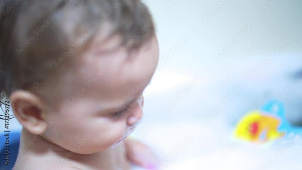 Happy little brothers playing together in the bath, A little baby and his brother playing together with the water and toys while taking a bath Happy little brothers playing together in the bath, A little baby and his brother playing together with the water and toys while taking a bath