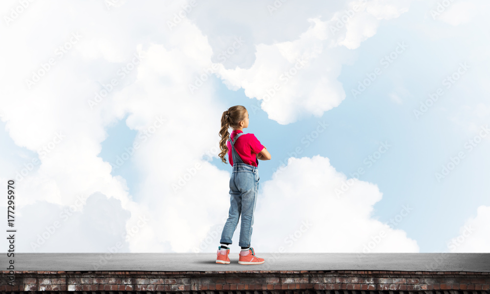 Concept of careless happy childhood with girl looking far away Concept of careless happy childhood with girl looking far away