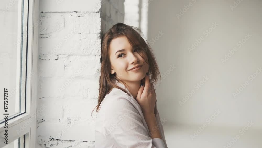 Attractive girl, in casual clothes, having fun while looking out of the window Attractive girl, in casual clothes, having fun while looking out of the window