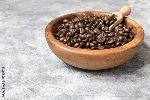 Coffee beans in a wooden bowl on a light marble background with copy space in a minimalist style