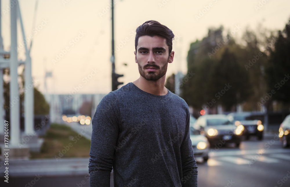 Attractive young man portrait at night with city lights behind him in Turin, Italy Attractive young man portrait at night with city lights behind him in Turin, Italy