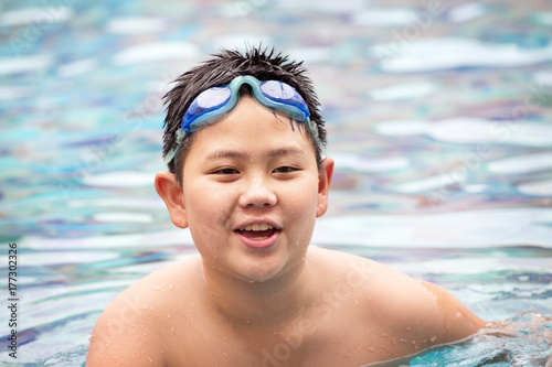 young boy swimming in pool.