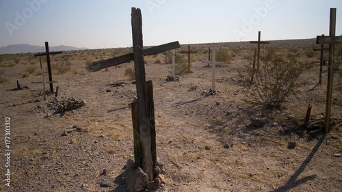 UNMARKED WOODEN CROSSES IN A DESERT CEMETERY, IN 4K.  Slow, wide dolly shot of a desert cemetery.  Shot in 4K, 10 bit, 4:2:2.