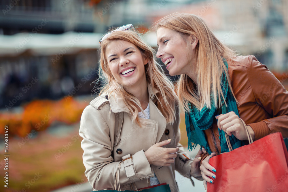 Happy friends shopping. Two beautiful young women enjoying shopping in the city.