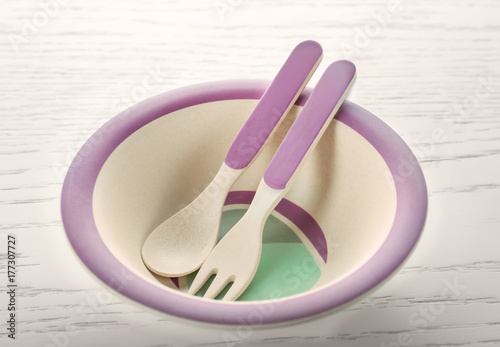 Bright baby tableware on wooden table