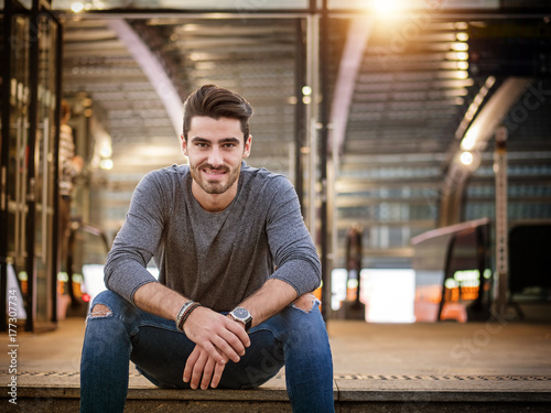 Attractive young man portrait at night with city lights behind him in Turin, Italy