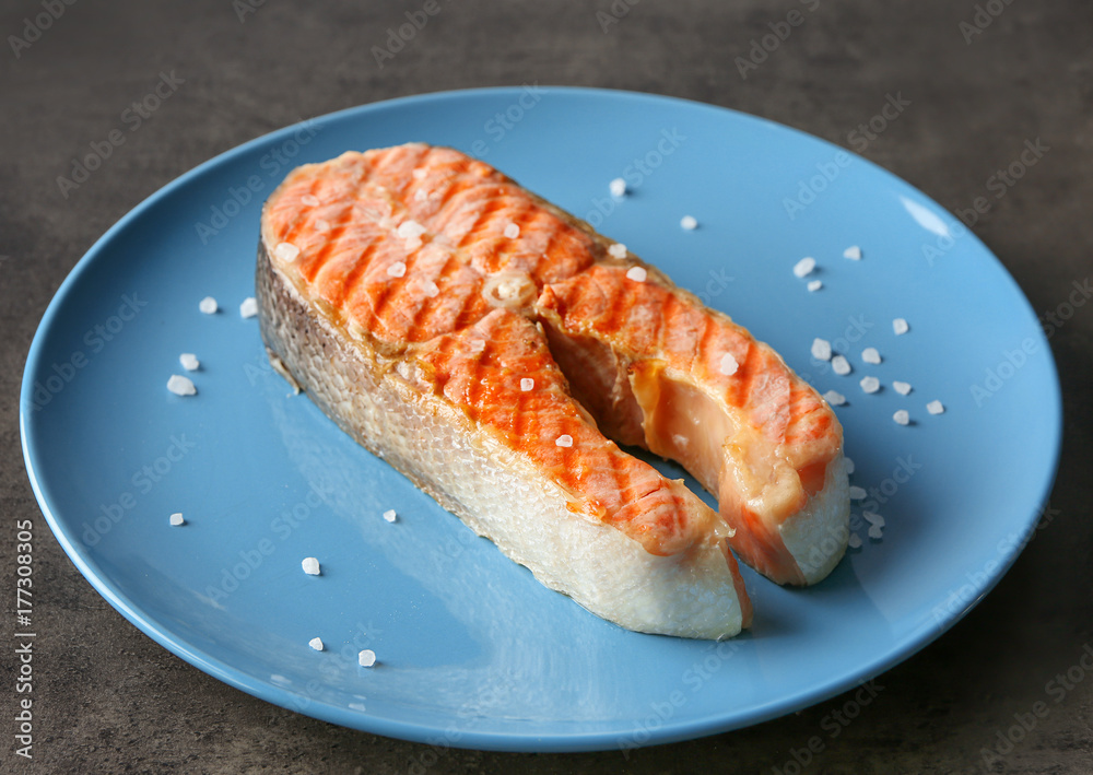 Plate with delicious salmon steak on table Plate with delicious salmon steak on table