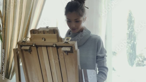 Beautiful young girl makes a coffee break during drawing picture photo