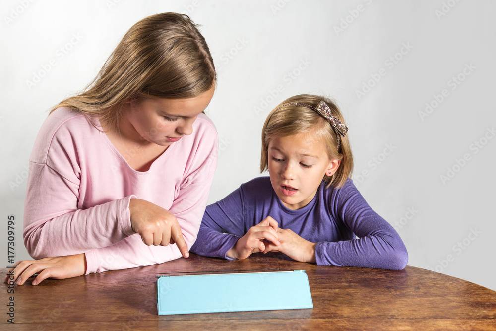Little girls playing on a tablet computing device Little girls playing on a tablet computing device