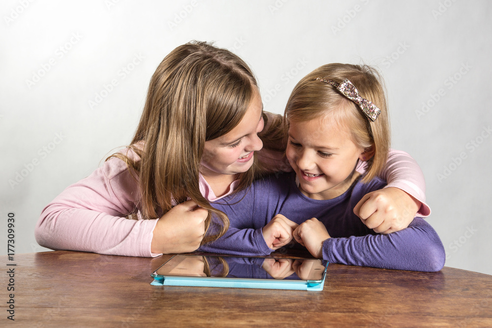 Little girls playing on a tablet computing device Little girls playing on a tablet computing device