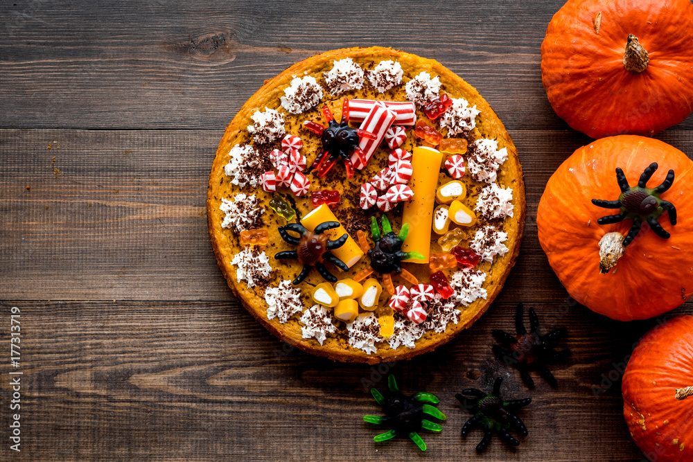 Gummy spiders crawls toward pie for halloween on wooden background top view copyspace Gummy spiders crawls toward pie for halloween on wooden background top view copyspace