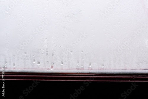 High humidity, condensing large drops of condensed water flow down the glass. Texture of water on a glass background