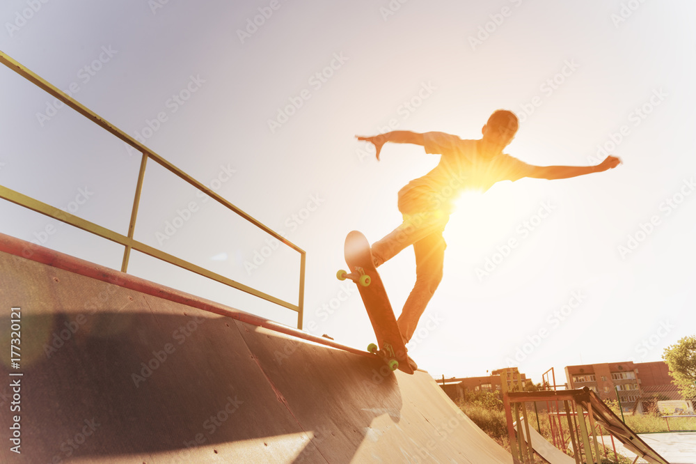 Φωτογραφία Teen skater hang up over a ramp on a skateboard in a skate park