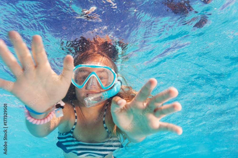Naklejka premium Cute little girl snorkeling in the pool