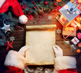 Santa Claus Desk Reading Wish List With Ornament And Christmas Gift
