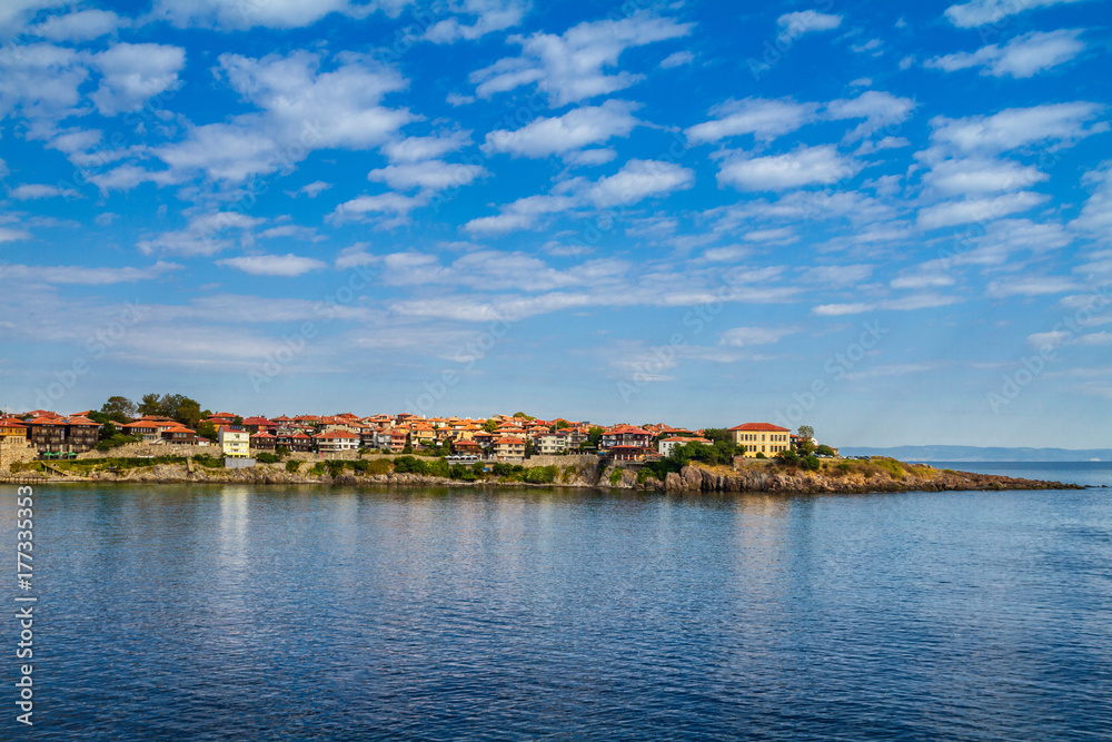 Coastal landscape - the rocky seashore with houses under the sky with clouds, town of Sozopol on the Black Sea coast in Bulgaria