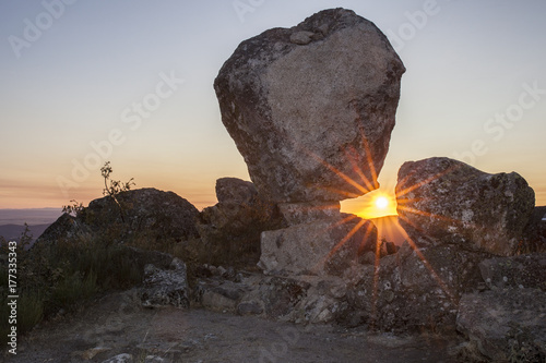 Sun rising between megalithic monument, Montanchez, Spain photo