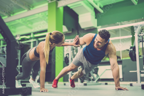 Fototapeta Naklejka Na Ścianę i Meble -  The man and woman doing push up exercise and gesture in the gym