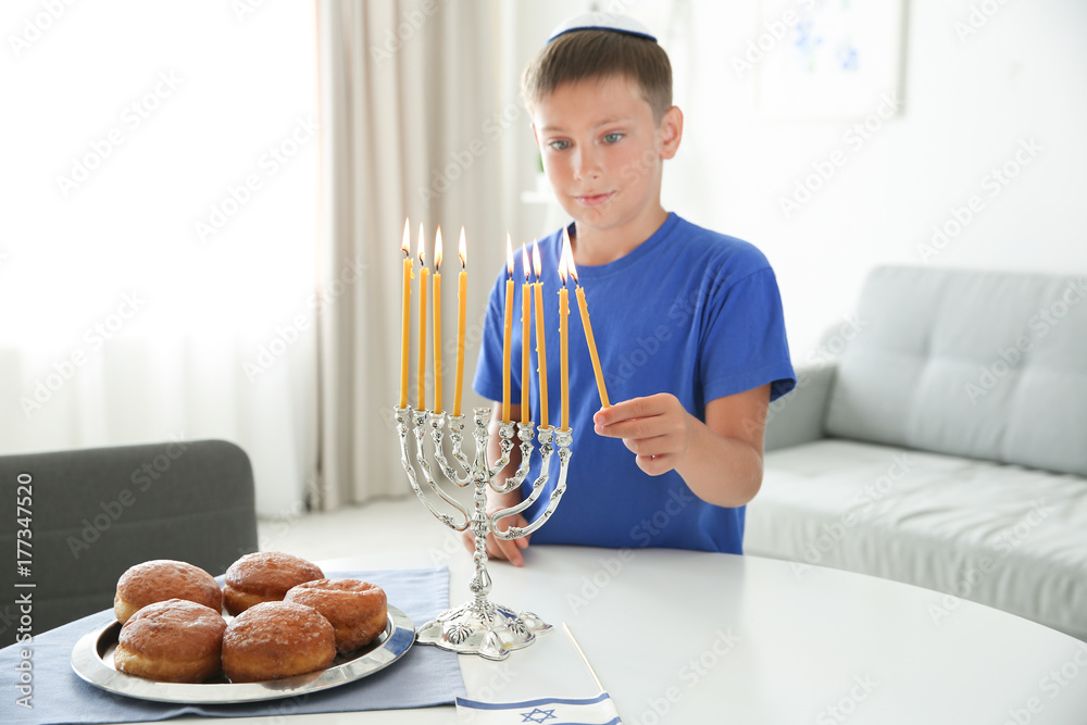 Jewish boy lightning menorah at home Jewish boy lightning menorah at home