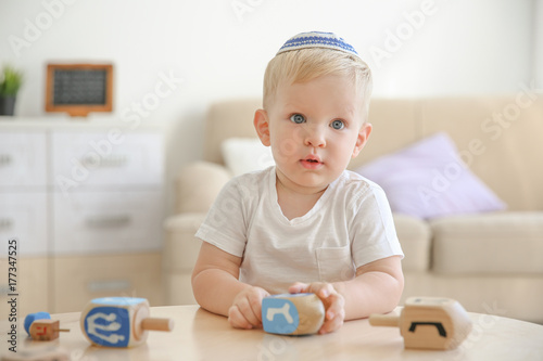 Jewish boy playing with dreidel at home