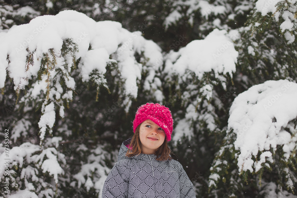 Smiling girl with bright pink hat plays in snow Smiling girl with bright pink hat plays in snow