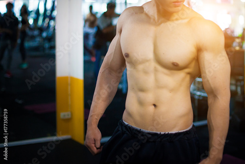 Handsome young Asia Male bodybuilder, fitness model trains in the gym