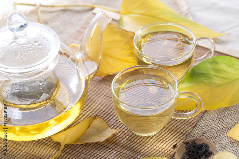 Autumn tea. Glass teapots and cups with autumn leaves on table. Autumn tea. Glass teapots and cups with autumn leaves on table.