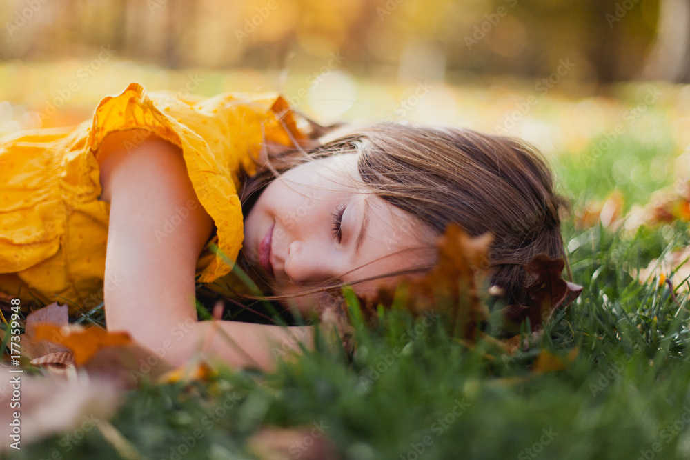 Girl wearing gold top rests in leaves Girl wearing gold top rests in leaves