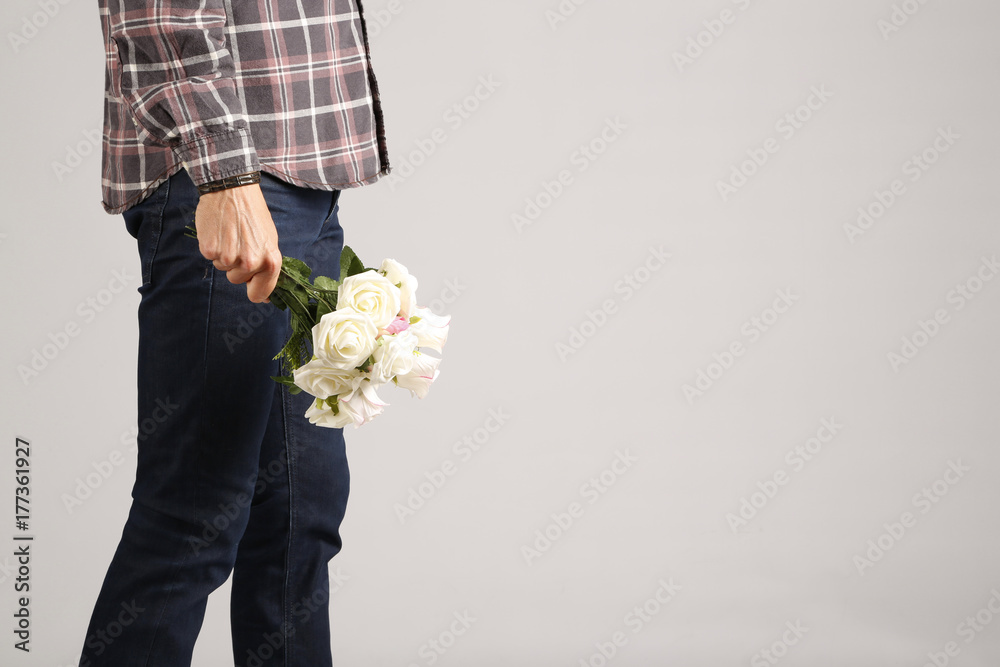 hombre con ramo de flores en la mano foto de Stock | Adobe Stock
