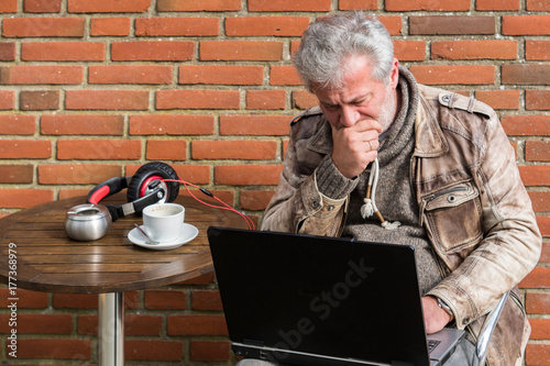 Geschäftsmann arbeitet am Laptop in einem Straßencafé