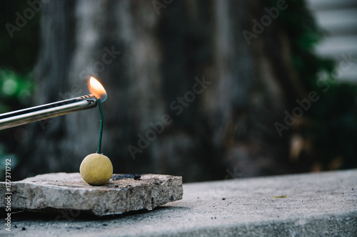 Lighter igniting the fuse of a smoke bomb